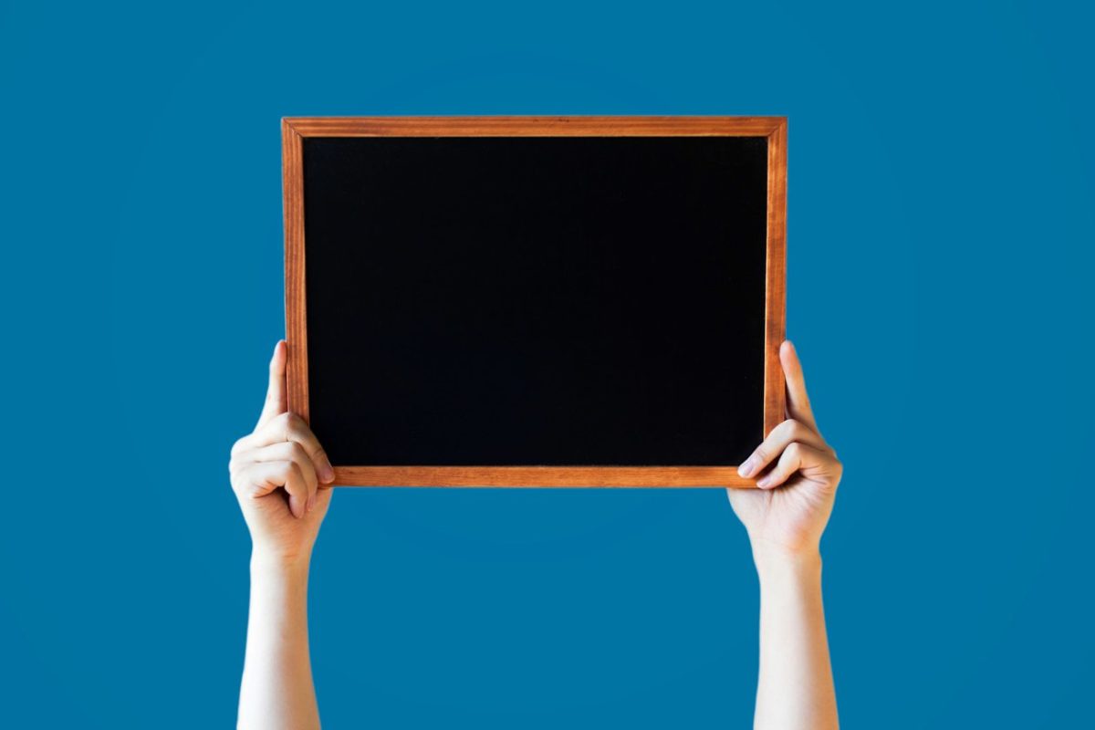 手持黑板图片素材 Human Hands Holding Empty Blank Black Board Over Blue Background – Ready for adding your text here
