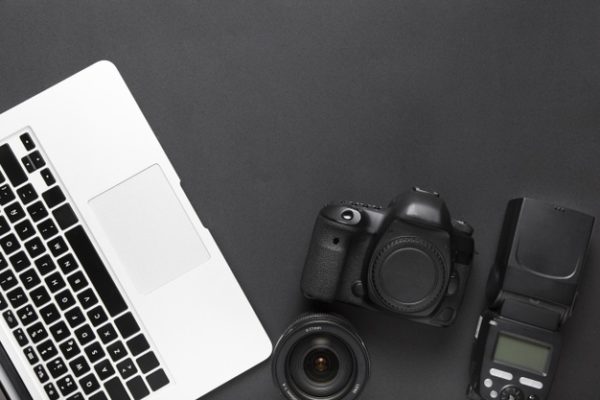 摄影师顶视图桌面背景 Flat lay of camera and laptop keyboard with copy space Photo